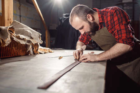 Working process in the leather workshop. Tanner in old tannery.