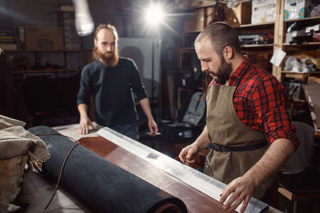 Working process in the leather workshop. Tanner in old tannery.