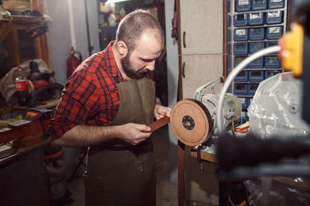 Working process in the leather workshop. Tanner in old tannery.
