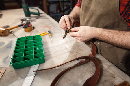 Close up of hands tanner performs work on table with toolsの写真素材