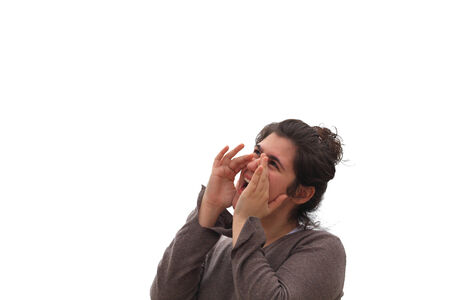 Young woman shouting, with hands on mouthの写真素材