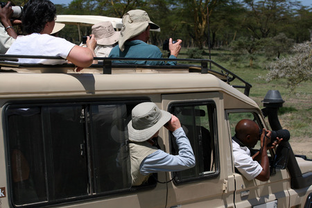 MASAI MARA, KENYA - JUNE 10, 2009 Some tourists taking photos at wildlife, during a safari tour on June 10, 2009 in the Masai Mara national park, Kenyaのeditorial素材