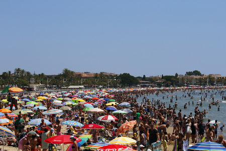 SALOU, SPAIN - JULY 06: People relaxing on the beach to have their holidays on July 06, 2013 at the coast of Salou, Spain, a famous tourist destinationのeditorial素材