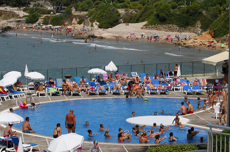 SALOU, SPAIN - AUGUST 06, 2013: Lots of tourists having fun in the pool and beach, swimming in blue water, on August 06 at the famous tourist area of Salou, Spainのeditorial素材