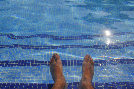 Human feet in a pool, transparent water