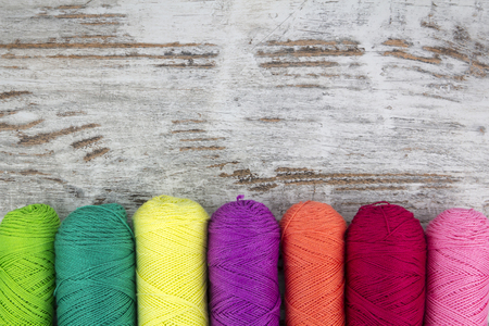 Colorful sewing threads in a wood backgroundの写真素材