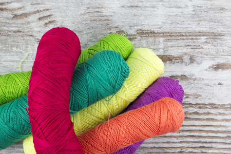 Colorful sewing threads in a wood backgroundの写真素材