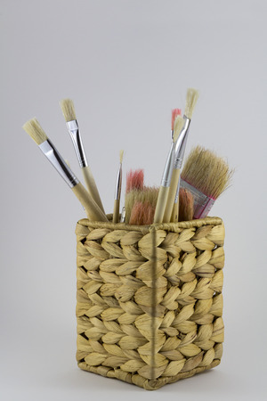 Set of paintbrushes in a wicker potの写真素材