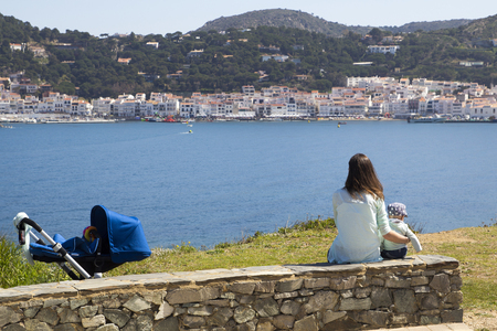 Mom and son sitting in the coast of Port de la Selva, in Catalonia, Spainの写真素材