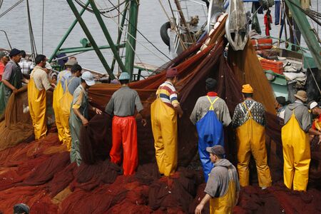 ESSAOUIRA, MOROCCO - AUGUST 09, 2011: Local harbor, with some fisherman working with nets at the city of Essaouira, Mogador in August 09, 2011, Moroccoのeditorial素材