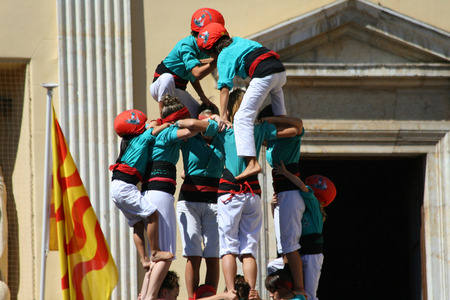 TARRAGONA - SPAIN. SEPTEMBER 19, 2010 - People making human towers, a traditional spectacle in Catalonia called "castellers", with people climbing and making high structures in the city of Tarragona, on September 19, 2010のeditorial素材