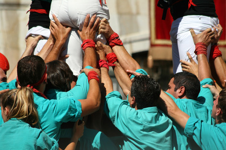 TARRAGONA - SPAIN. SEPTEMBER 19, 2010 - People making human towers, a traditional spectacle in Catalonia called "castellers", with people climbing and making high structures in the city of Tarragona, on September 19, 2010のeditorial素材
