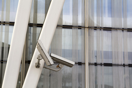 Security cam for video surveillance, against a glass building