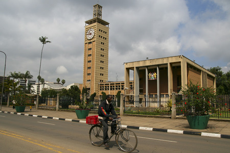 NAIROBI, KENYA - June 07, 2009: Kenyan man cycling in a bike at the center of Nairobi, with a christian church in the background,  on June 07, 2009 in Nairobi, Kenyaのeditorial素材