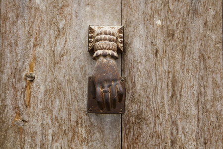 Old metal knocker in a wooden door
