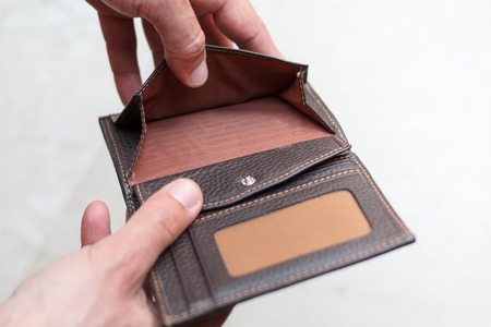 Hands holding an open wallet with no money