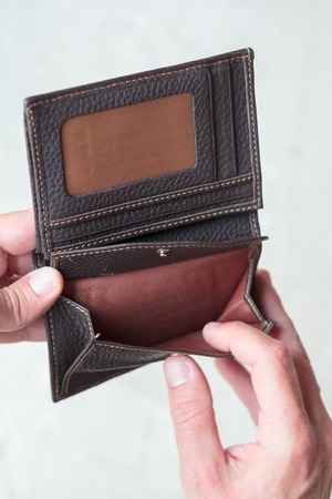 Hands holding an open wallet with no money