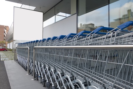 Blank billboard mock up in a supermarket, in front of shopping cartsの写真素材