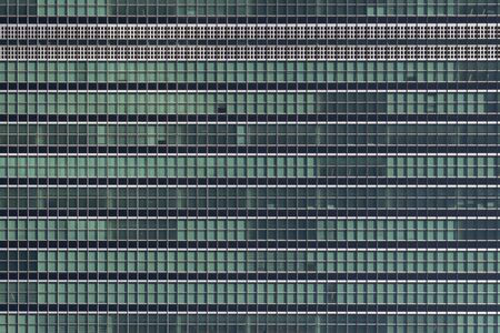 Many windows in a glass financial building with offices