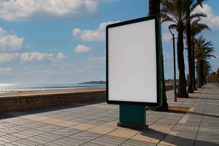 Blank billboard mock up in a sidewalk, next to the seaの写真素材