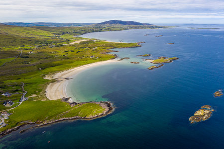 Emerald coastline with a curved sandy beach, turquoise sea, and rocky inlets, Galway, Ireland