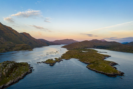 A tranquil aerial view shows a chain of green islands lining a winding inlet, with calm blue water, Galway, Irelandの写真素材