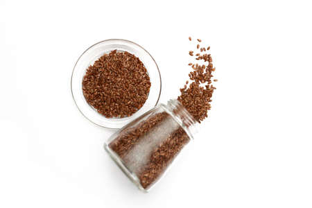 Scattered flaxseeds in the glass container. Top view.の写真素材