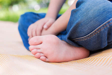 Foot of seated child on picnic or yoga. Selective focus