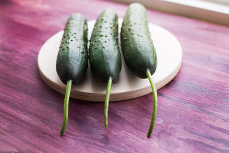 Three fresh cucumbers lying on a windowsillの写真素材