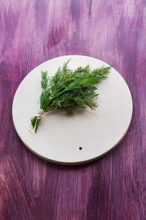 Bunch dill lying on a light plateの写真素材