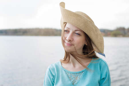 Happy girl in hat thinking on a windy day