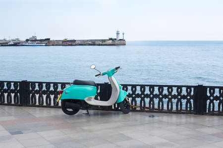 Light green scooter standing on the waterfrontの写真素材