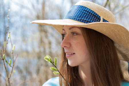 Freckled happy girl in thatch hat looking away in springtimeの写真素材