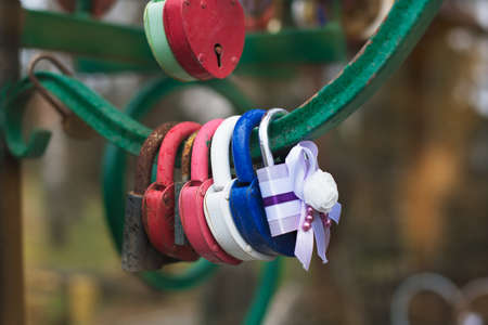 Hanging different wedding padlocks in rainy weatherの写真素材