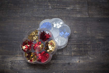 Sequins in two boxes on wooden backgroundの写真素材