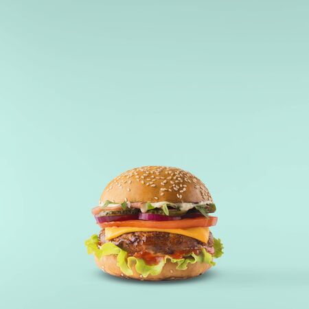 Delicious burger isolated on turquoise backgroundの写真素材