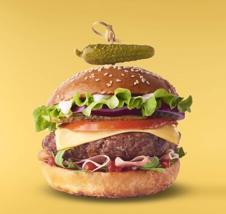 Delicious burger isolated on yellow backgroundの写真素材