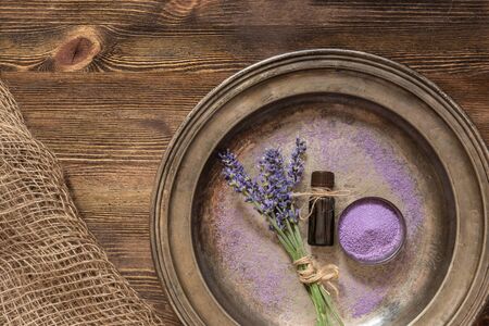 Lavender flowers, bath salt and lavender oil on a wooden background.の写真素材