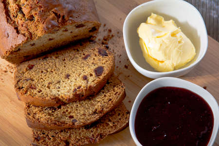 Date Loaf, Jam and Butter on Cutting Boardの写真素材