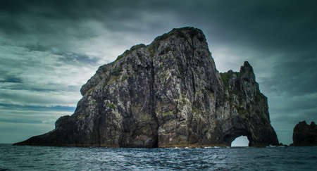 Dramatic view of Hole in The Rock on a stormy day in the Bay of Islands New Zealand
