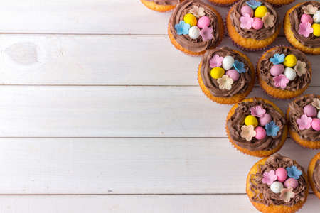 Easter Cup Cakes from Above with Copy Space on White Wooden Tableの写真素材