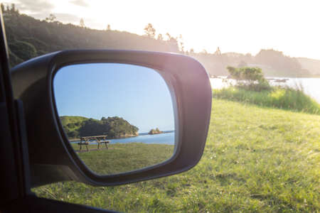 Road Trip View of Beach and Picnic Table with Sun Flare, Bay of Islands, New Zealandの写真素材