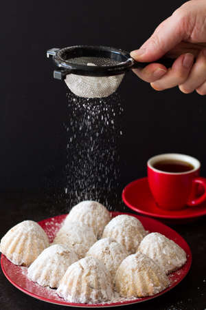 Dusting Egyptian Eid Cookies with Icing Sugar, Vertical