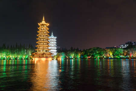 The Sun and Moon Pagoda at Night over the Lake Guilin Chinaの写真素材