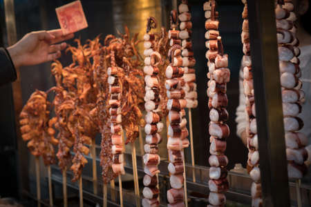 Chinese Street Good - Man Buying Octopus Tentacles in Xian China Selective Focusの写真素材