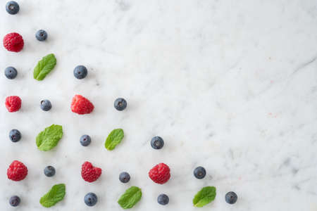 Pattern of Blueberries, Raspberries and Mint on Marble Table top with Copy Spaceの写真素材