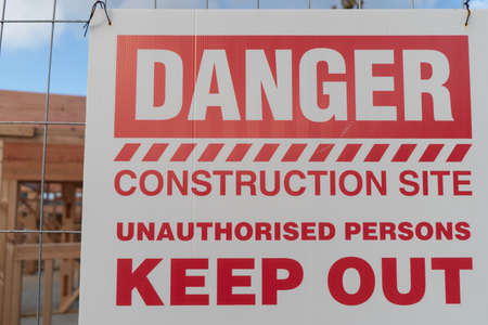 Sign at Construction Site - Danger Unauthorised Persons Keep Out, with Building in Background, in Auckland New Zealandの写真素材