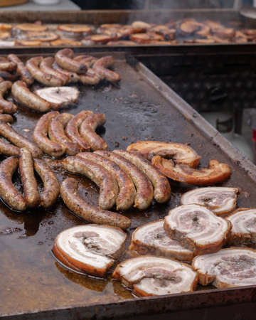 Sausages and Chops on the Barbecue at a Street Market Vertical Selective Focusの写真素材