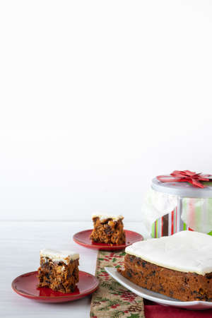 Rich Fruit Christmas Cake on Table with Present on light background with copy space Vertical