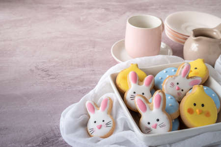 Plate of Easter Cookies with Tea cups and Saucers Ready Selective Focus with Copy Space on a Light...